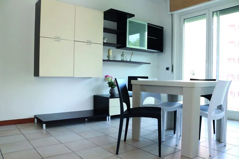 Cucina lineare bianca e nera di Casa Martina con tavolo da pranzo e porta finestra sul balcone