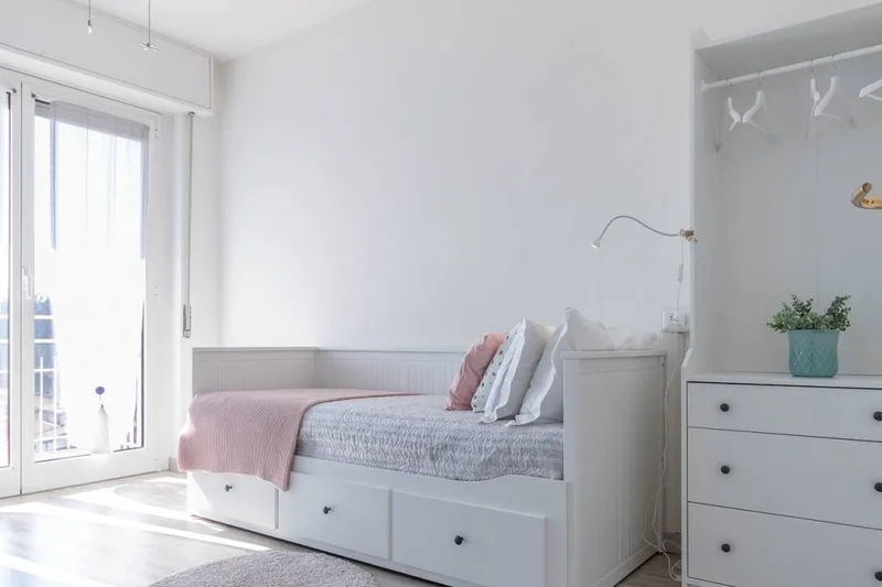 Camera singola de Il Girasole con letto contenitore bianco, cassettiera e portafinestra che dà luce naturale