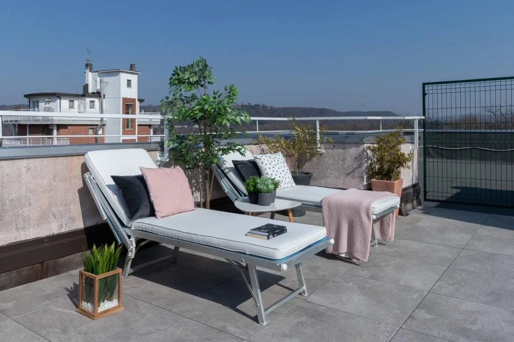 Due lettini prendisole con cuscini rosa sul terrazzo de La Terrazza, sotto il cielo terso del Lago Maggiore